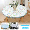 White floral patterned round tablecloth displayed on a wooden table with chairs.