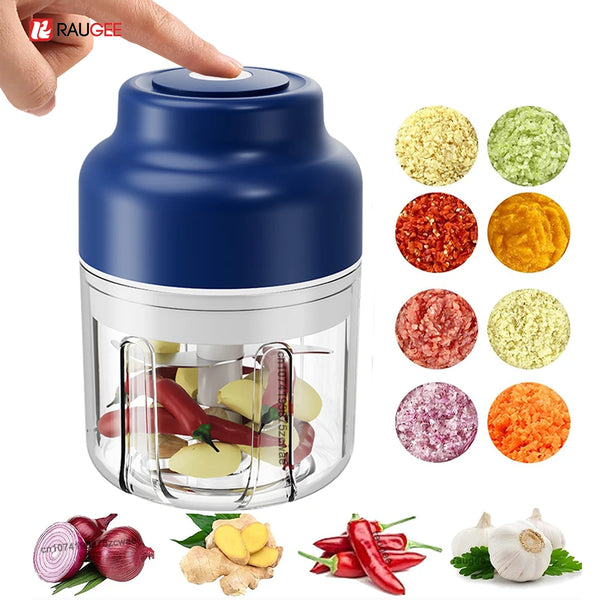 A portable electric food chopper with a clear jar and a lid, surrounded by various ground spices and ingredients.