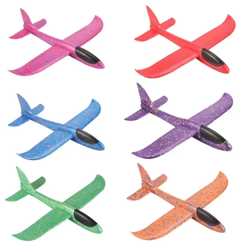 A collection of five foam glider planes in various colors including pink, red, blue, purple, and orange.