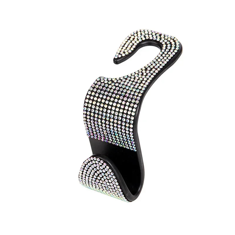 A black car headrest hook with a curved design, covered in clear rhinestones.