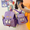 Eine Person hält einen lila Dora the Explorer Flanell-Rucksack vor einem orangefarbenen Hintergrund.