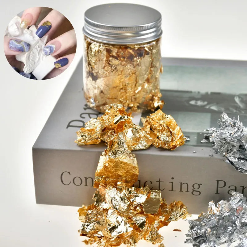 Jar of metallic gold foil flakes for crafting and nail art alongside loose flakes.