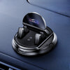A black anti-slip dashboard phone mount with a rotating mechanism is shown on a dark blue car interior.