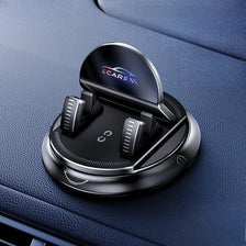 A black anti-slip dashboard phone mount with a rotating mechanism is shown on a dark blue car interior.