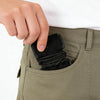 A hand is inserting black adjustable luggage connector straps into a pocket of olive green fabric.