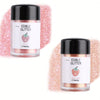 Two glass jars of edible glitter powder, one pink and one rose gold, for baking and dessert decoration.