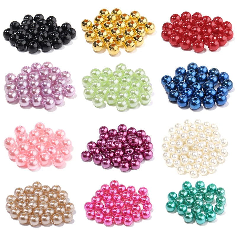 A collection of round imitation pearl beads in various colors including black, gold, red, pink, green, blue, and white.