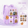 A purple Capybara Kids school backpack with ergonomic support, showing various stuffed capybara figures.