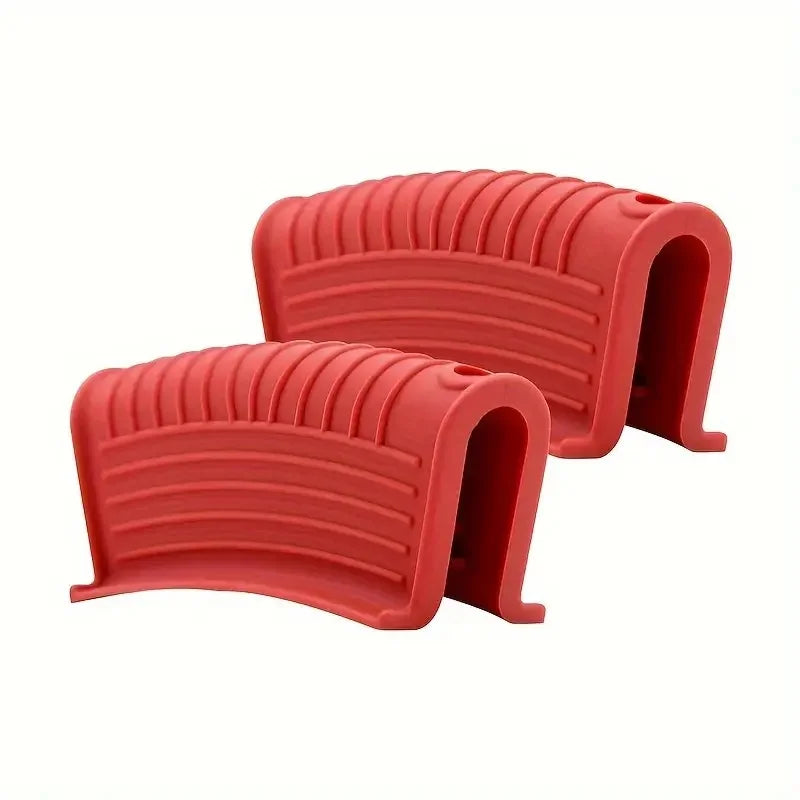 A pair of red heat-resistant silicone pan handle covers, shaped like curved grips.