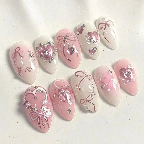 Un set de uñas postizas de presión en rosa y blanco con detalles de purpurina.