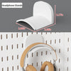 White headphone stands shown next to a pegboard organizer with hooks and shelves.