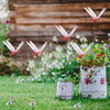 Lifelike dragonfly clips suspended from thin wires in a garden setting