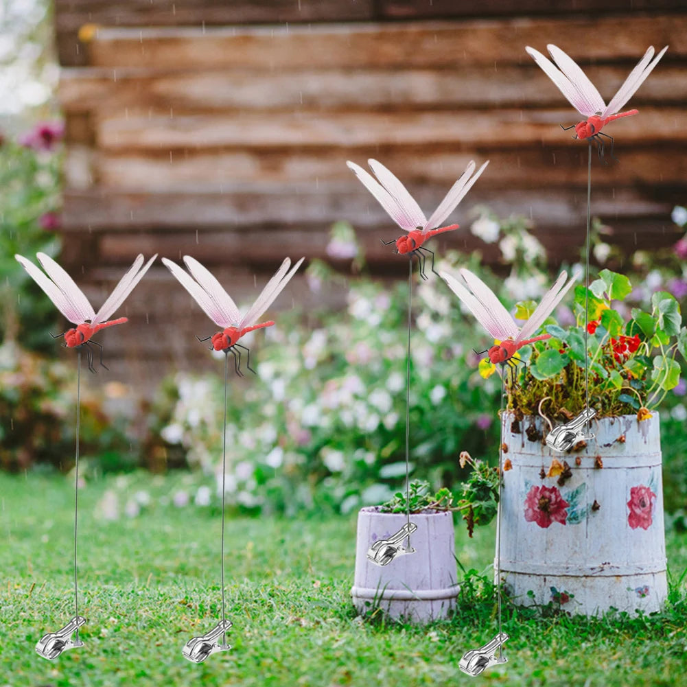 Lifelike dragonfly clips suspended from thin wires in a garden setting