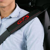 A person wearing a light blue shirt has a black leather seat belt cover with the letters GTS visible on it.