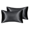 A set of two black silky satin pillowcases for hair and skin.