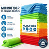 A stack of blue, green, and yellow microfiber cleaning cloths with a single green cloth in the foreground.