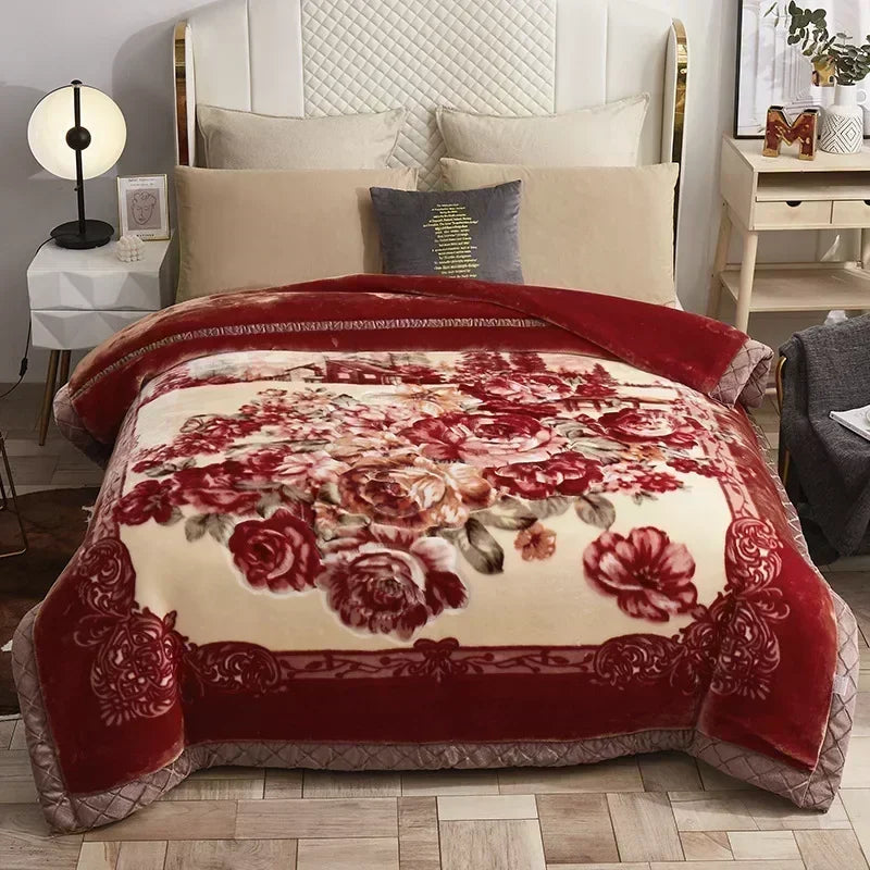 A richly colored red and cream weighted blanket with floral embroidery displayed on a bed.