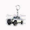 A silver metal key ring attached to a durable keychain featuring an off-road truck model.