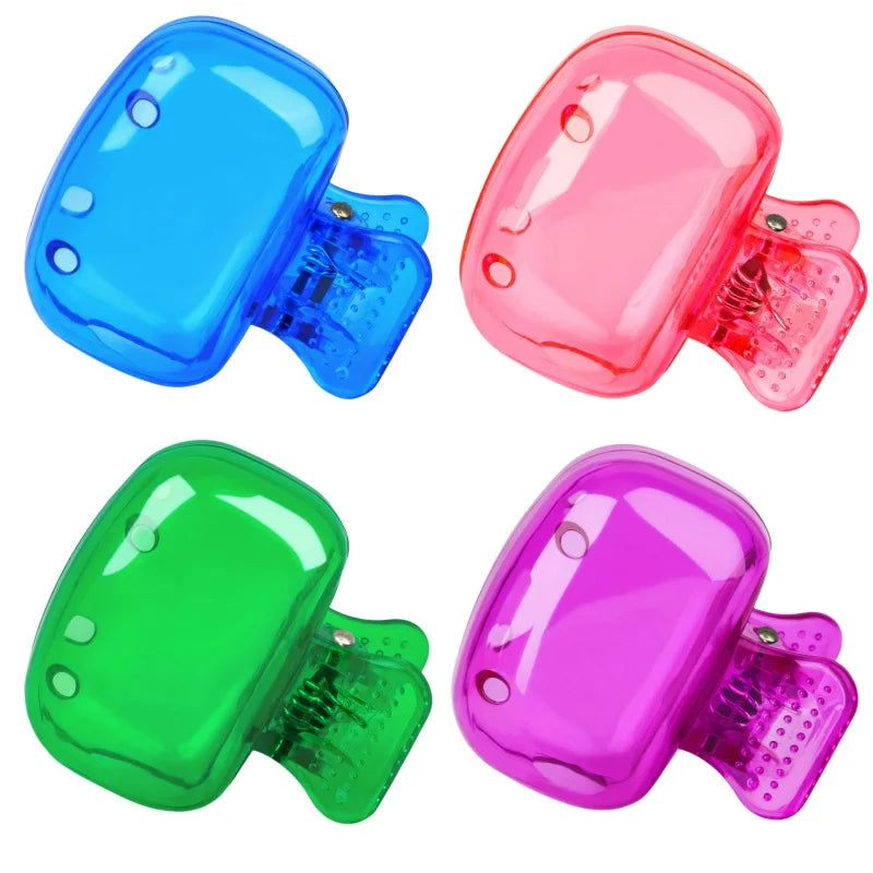 Three colored portable toothbrush head covers with clips in blue, pink, and green.
