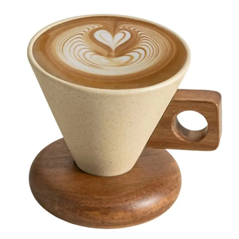 A latte art coffee in a ceramic cup resting on a wooden base with a spoon.