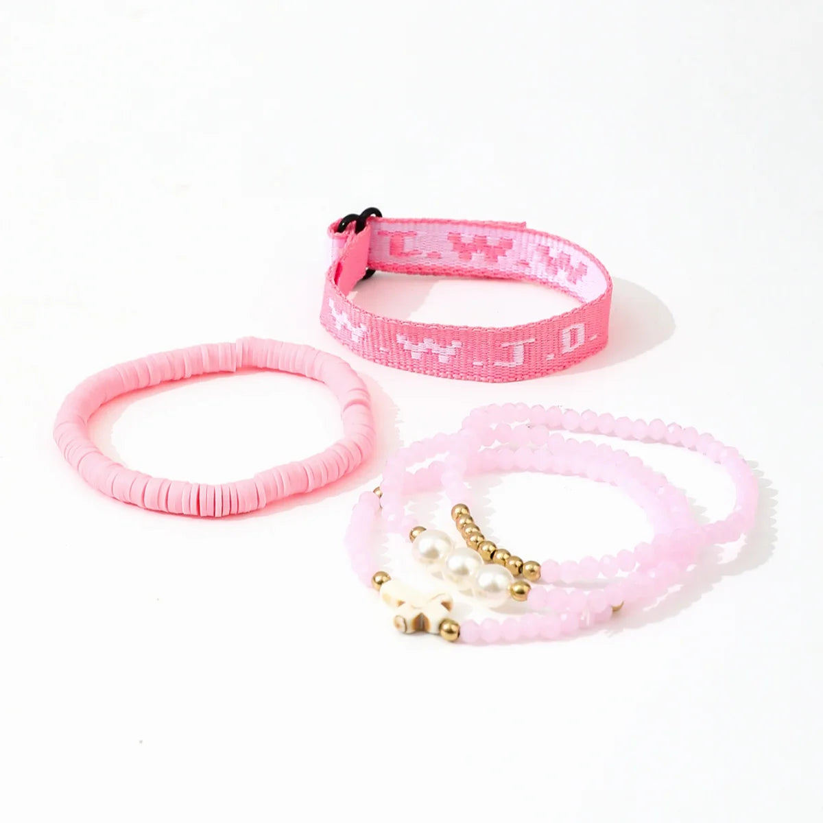 A set of pink beaded bracelets, including a pink wristband with white letters and several pink and white beaded bracelets.