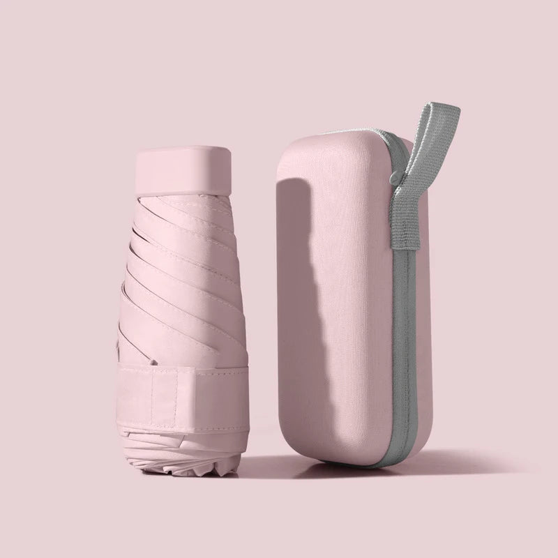 مظلة قابلة للطي وردية فاتحة مع حزام رمادي، تُعرض على خلفية باهتة.