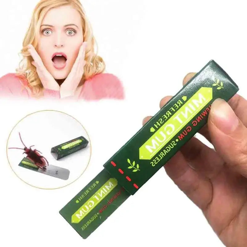 A hand holds a green piece of cockroach prank gum with a woman looking surprised in the background.