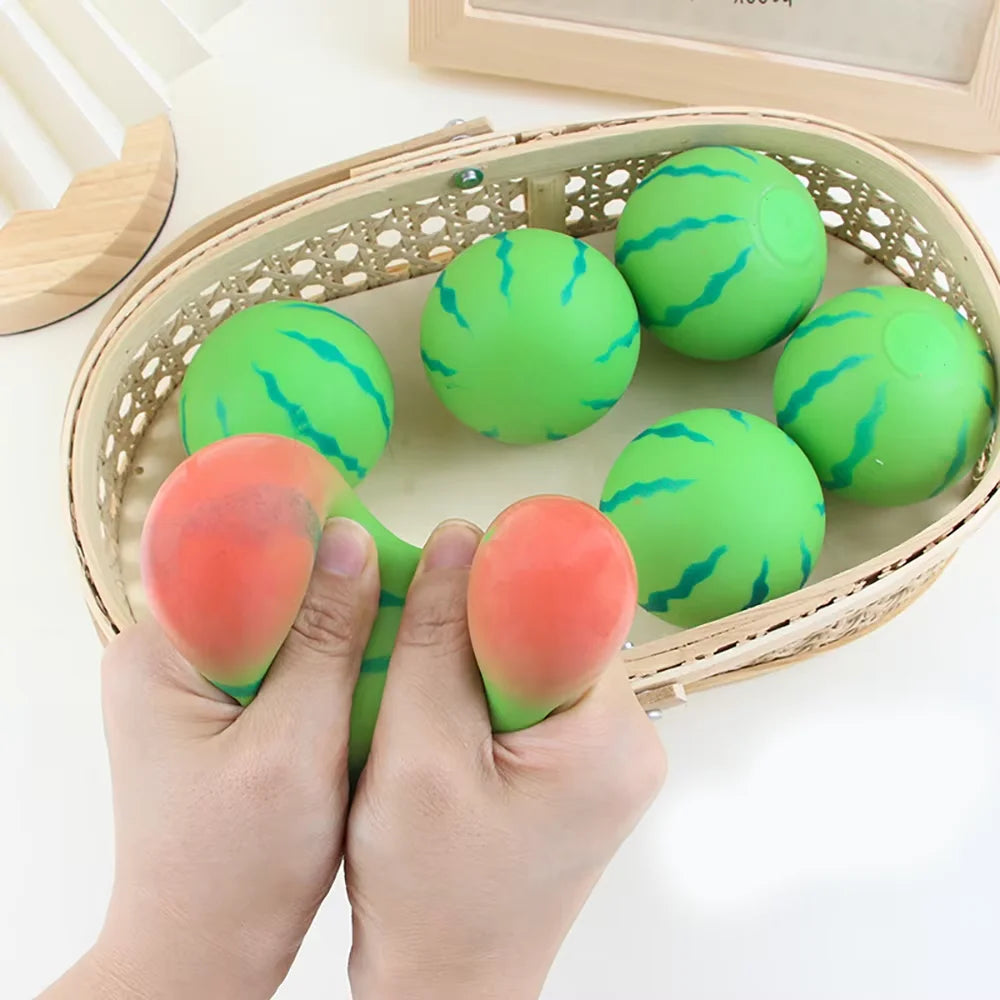 Eine Hand presst einen grünen Wassermelonen-Stressballspielzeug in einen geflochtenen Korb.