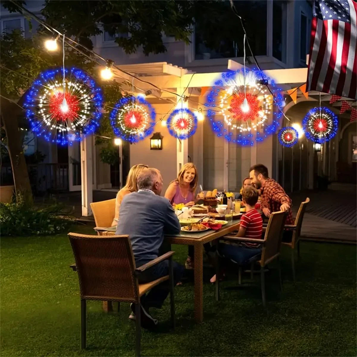 A family enjoying an outdoor dinner under string lights with colorful LED fairy lights illuminating the scene.