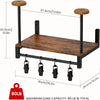 A black motorcycle helmet wall mount featuring a wooden shelf and four hanging hooks for storage.