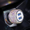 A close-up of a rhinestone dual USB car charger with blue accents inside its housing.