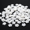 A pile of 100 white acrylic pearl spacer beads for jewelry making.