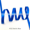 A blue satin ribbon is shown coiled and unwound against a white background.