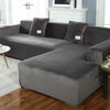 A gray plush velvet elastic sofa cover is shown on an L-shaped sectional sofa in a living room setting.