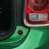 Close-up of a green car's taillight and fender with a circular marking indicating a location for anti-collision silicone pads