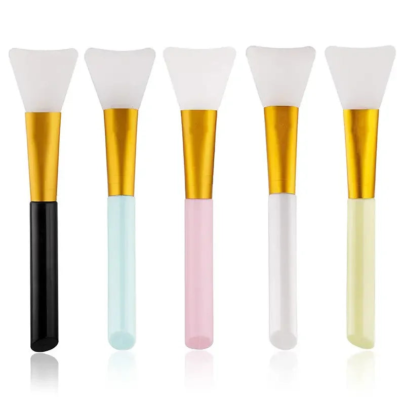 A set of five silicone facial mask brushes with white heads and gold bases in various pastel colors.
