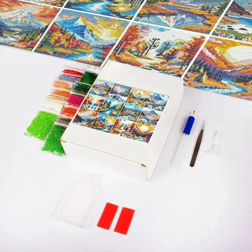 A box of 12 mini sunset mountain diamond painting kits with colorful mosaic images and tools.