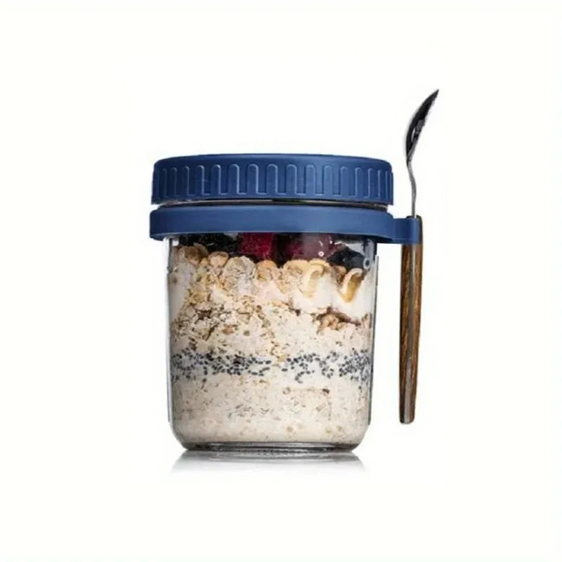 A glass overnight oats cup with a blue lid and a wooden spoon, filled with oats and berries.