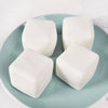 White squishy milk tofu fidget toys resting on a light blue ceramic plate.