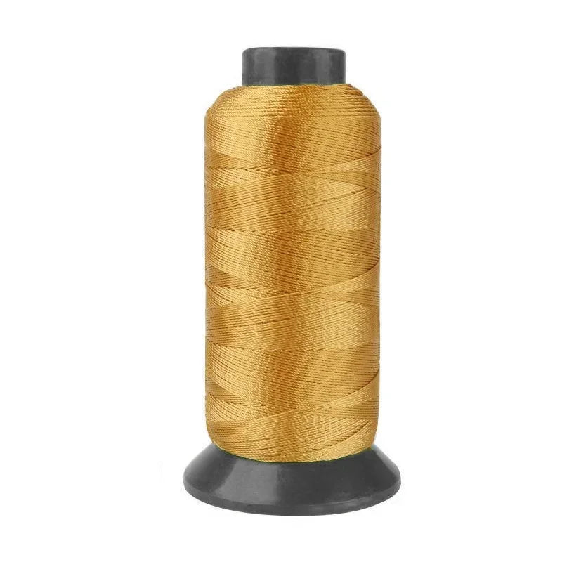 A spool of heavy-duty gold nylon sewing thread for upholstery and denim.