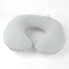A white inflatable U-shaped travel neck pillow with a clear strap visible.