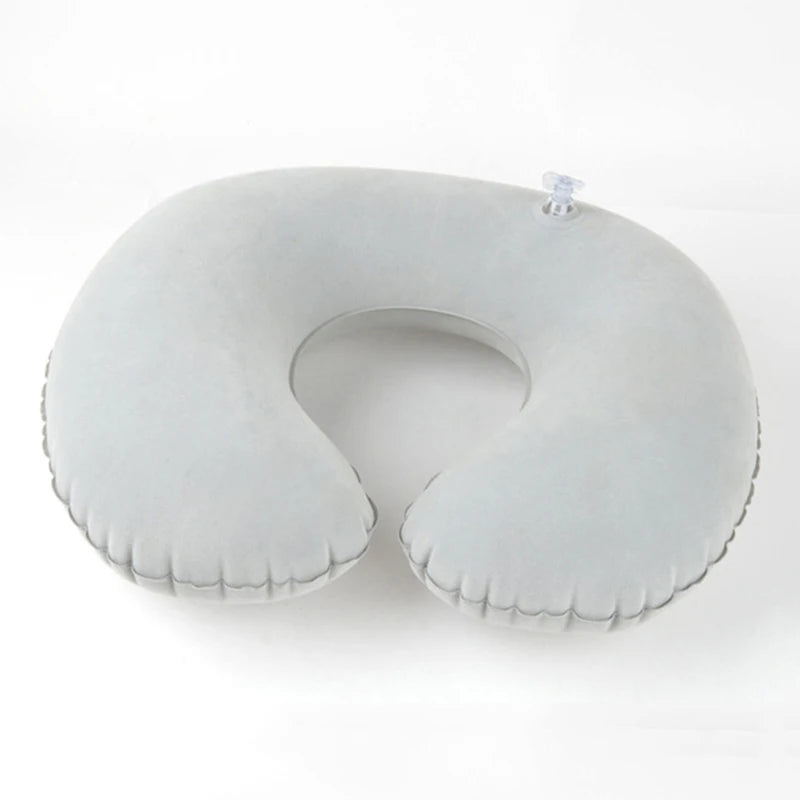 A white inflatable U-shaped travel neck pillow with a clear strap visible.