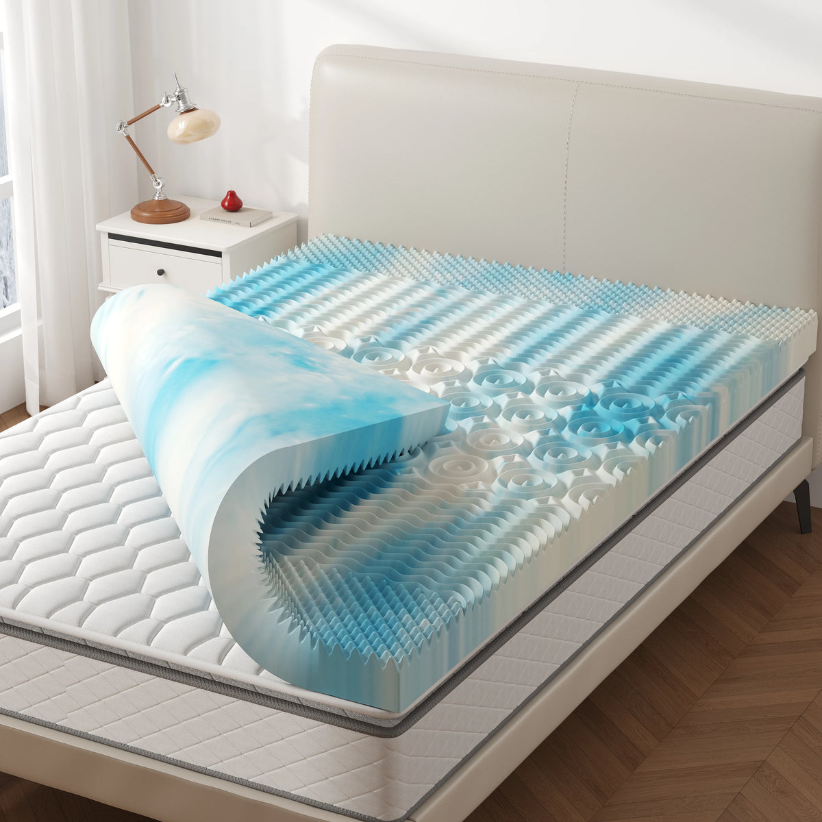 Memory-Schaum-Matratzenaufschlägler mit Kühlgel auf einem Bett, blau-weißes Wellenmuster.