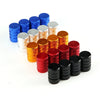 A set of four knurled aluminum tire valve caps in various shades of blue, silver, and copper.