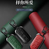 Three colored leather and metal car key cases displayed on a dark background.