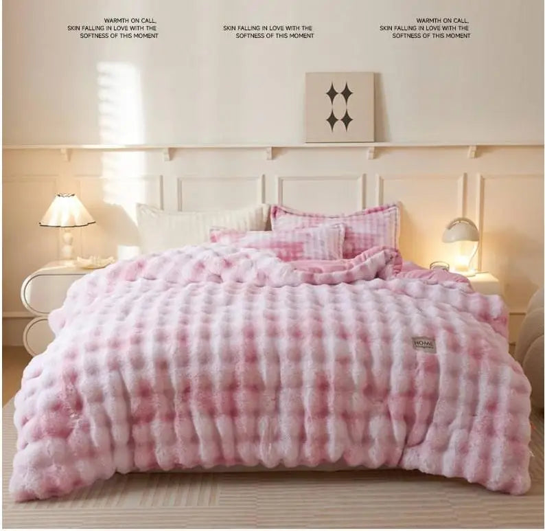 A pink and white checkered plush winter comforter is displayed on a bed with light wood accents.