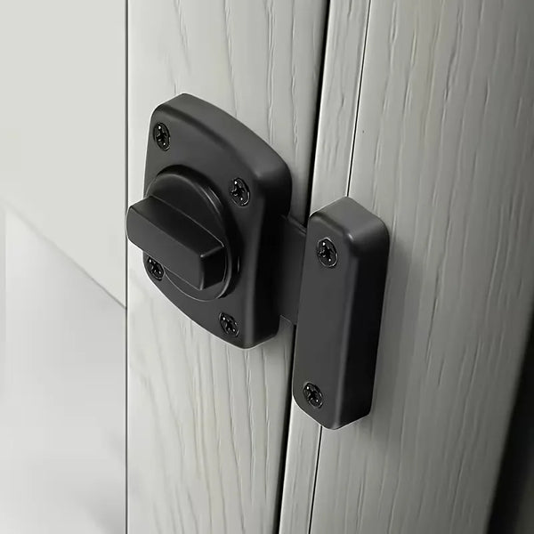 Verrou métallique lourd et rotatif noir installé sur une porte en bois blanc.