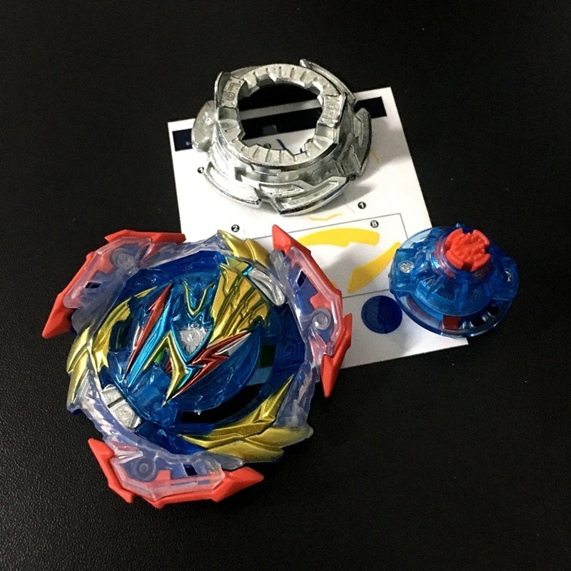 A metal battle spinning top with a blue and yellow design is shown next to a metal ring and a small blue object.