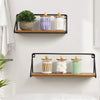 Three clear acrylic apothecary jars with wooden lids filled with lavender, white, and green bath salts displayed on a wooden 