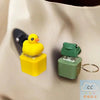 A yellow rubber duck fidget keychain with an LED light is shown next to a green frog fidget keychain on a white surface.